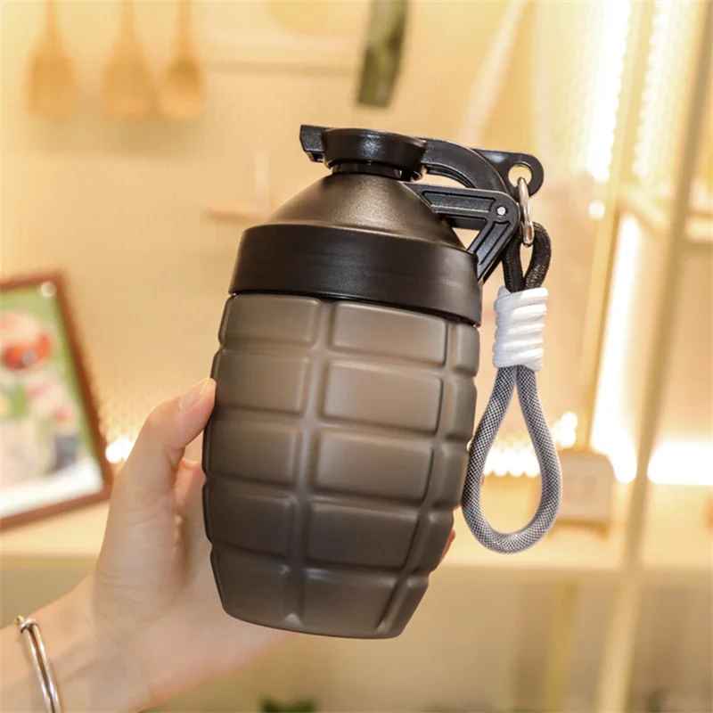 Shaker en forme de grenade noir tenu dans une main