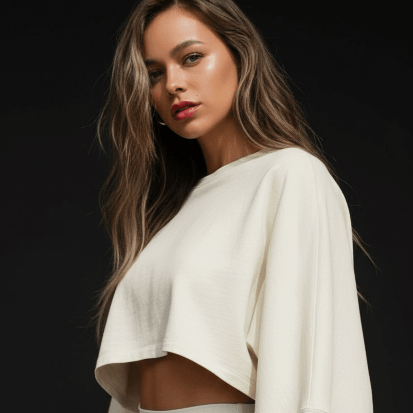 Femme portant un crop top blanc à manches courtes, scenique sur fond sombre, vue de trois-quarts. (Crop Top Femme Sport - Tee Shirt Court Manches Longues)