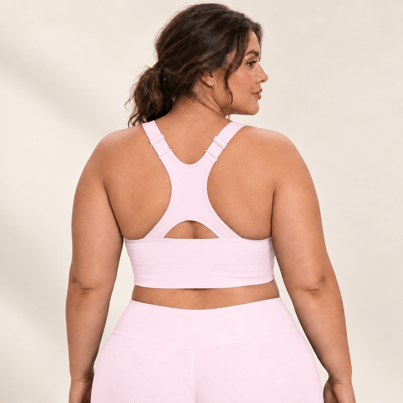 Brassière running maintien fort rose en grande taille, dos nageur à découpe, studio fond ivoire.