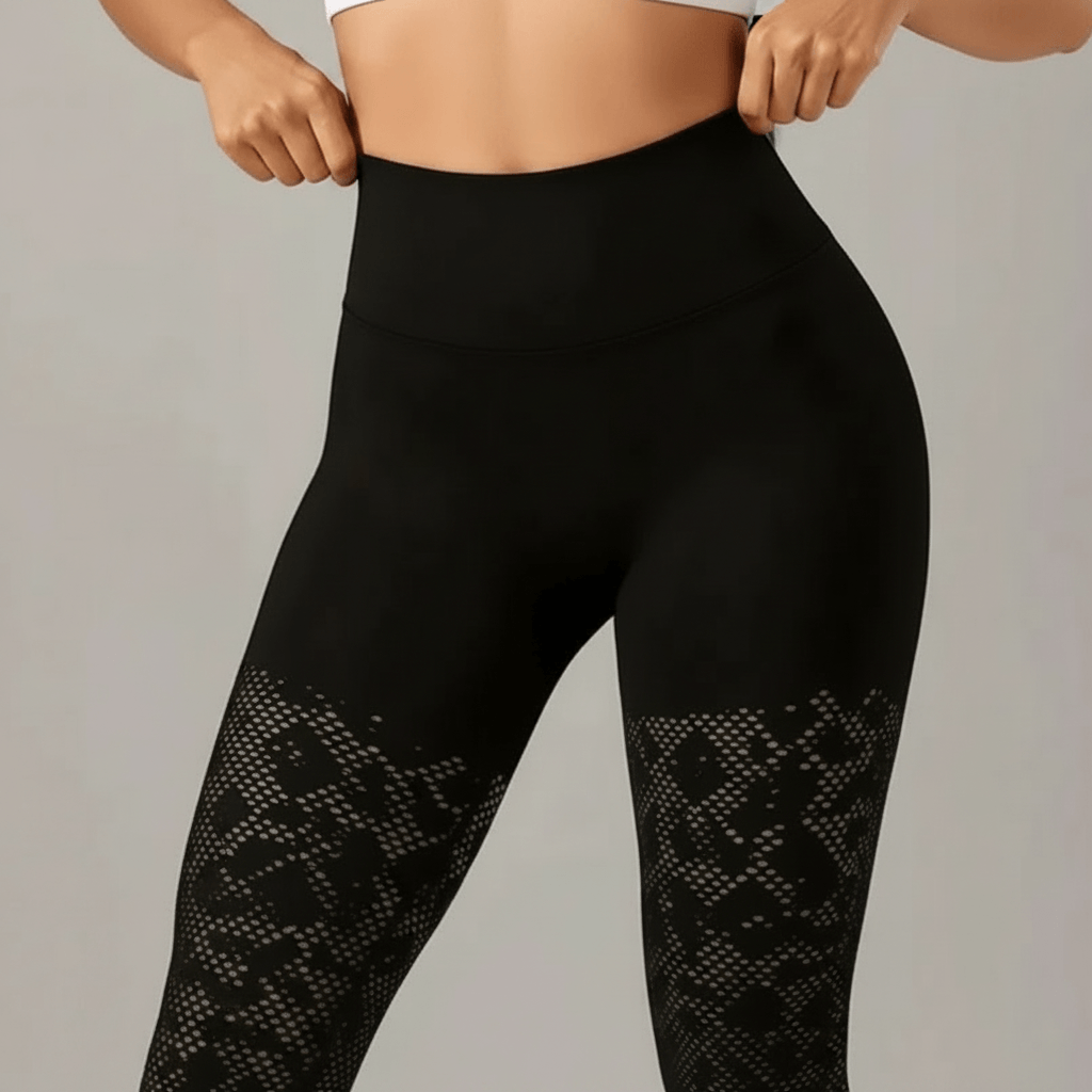 Zoom taille haute du legging de compression noir, ceinture gainante et détail dentelle mesh, fond ivory gray gris clair.