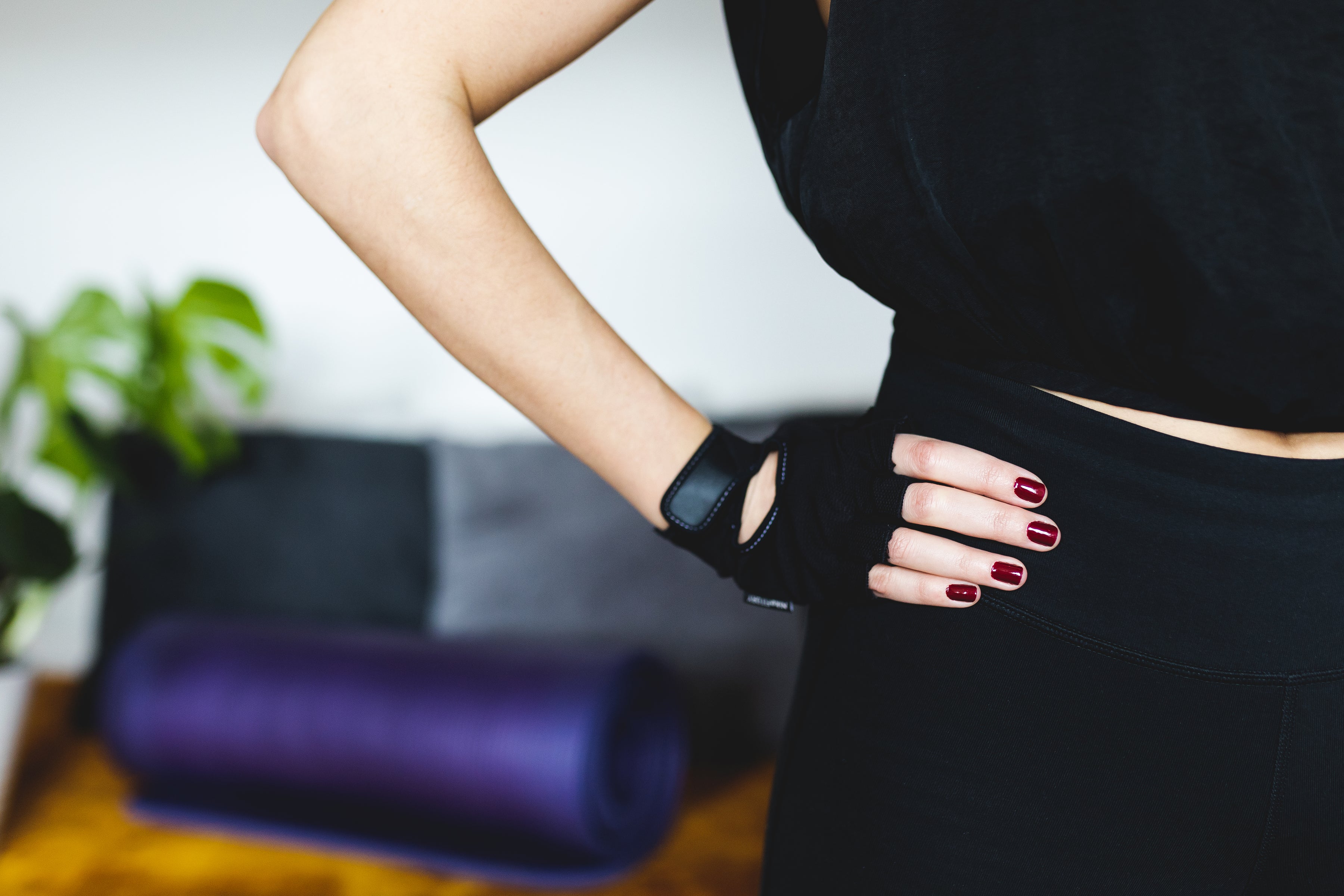 les mains avec de la manicure rouge portant un gant de musculation pour fitness