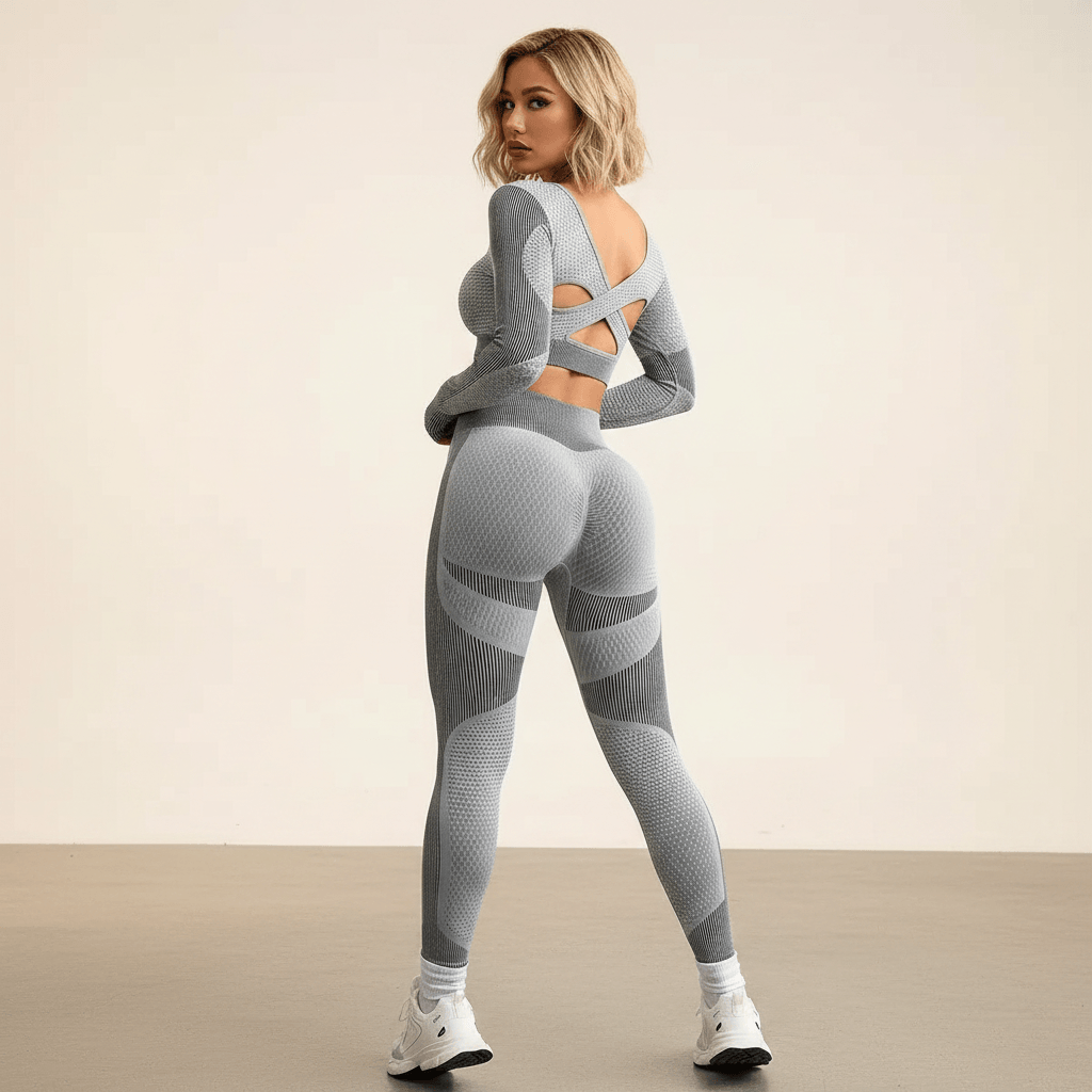 Tenue crossfit femme grise vue de dos, dos croisé découpé du crop top et effet scrunch du legging seamless, studio ivoire