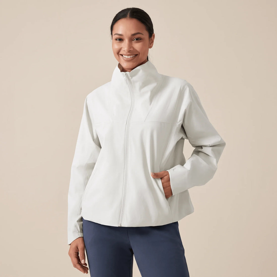 Veste running femme hiver blanc crème portée de face, col montant et zip pleine longueur