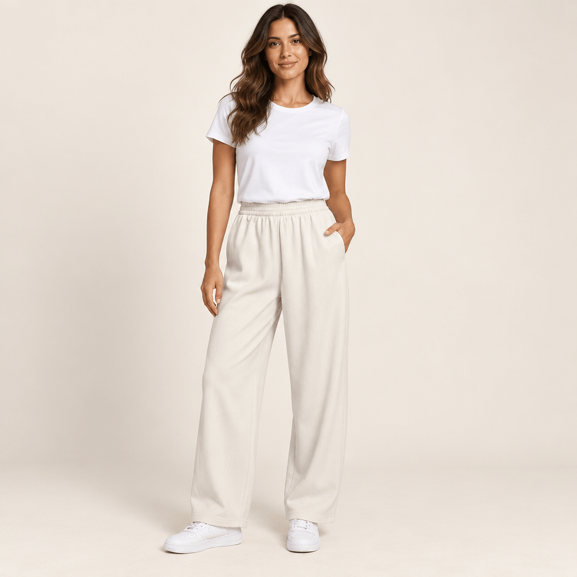 Pantalon sport femme ivoire à jambe large, taille élastique et poches latérales, porté de face avec un t-shirt blanc
