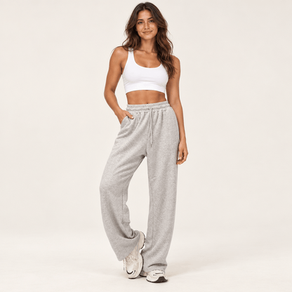 Jogging femme gris chiné à taille haute et jambe large, cordon de serrage et poches latérales, porté de face