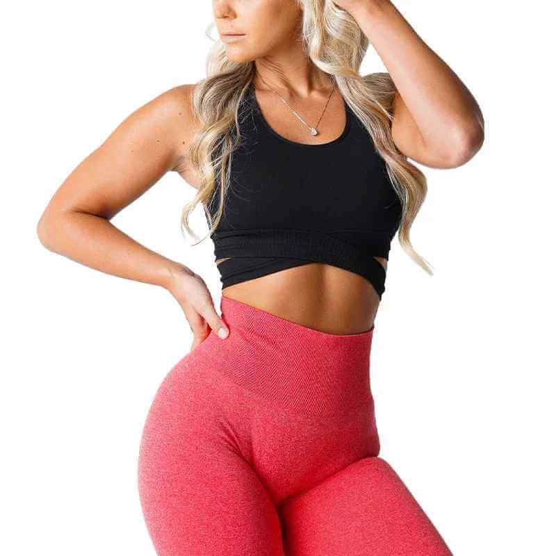 Brassière sport sans couture et legging rouge haute taille sur une femme active, pose confiante. XS-L disponible.