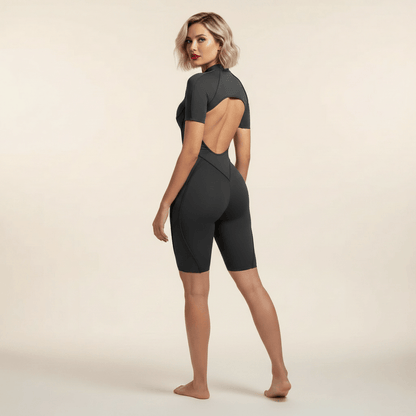 Combinaison fitness femme gris anthracite vue de dos, dos ouvert, bandes croisées V, shorts mi-cuisse
