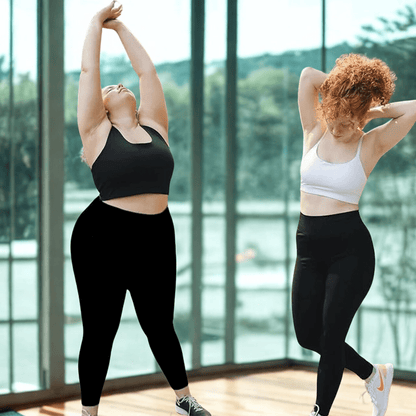 Femme souriante en legging grande taille noir, coupe taille haute confortable, épousant les courbes pour un style athleisure.