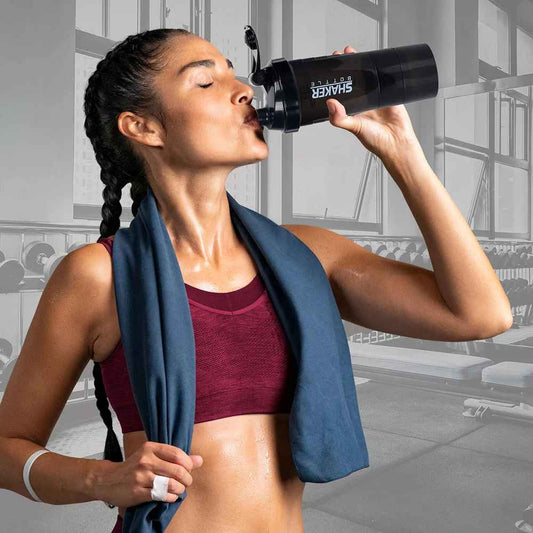 Femme utilisant le shaker triple compartiments à la salle de sport