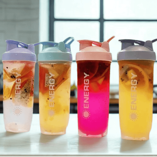 Gamme de shakers proteine Summer aux couleurs vives (rose, bleu, gris, violet) sur un fond estival.