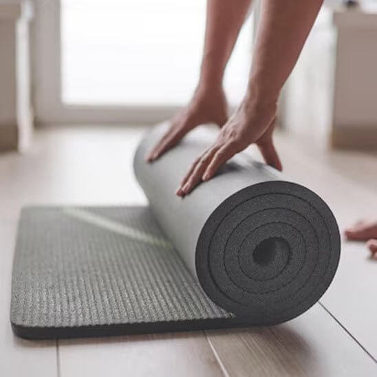 tapis du sport noir enroulé sur un parquet montrant son épaisseur et sa matière NBR