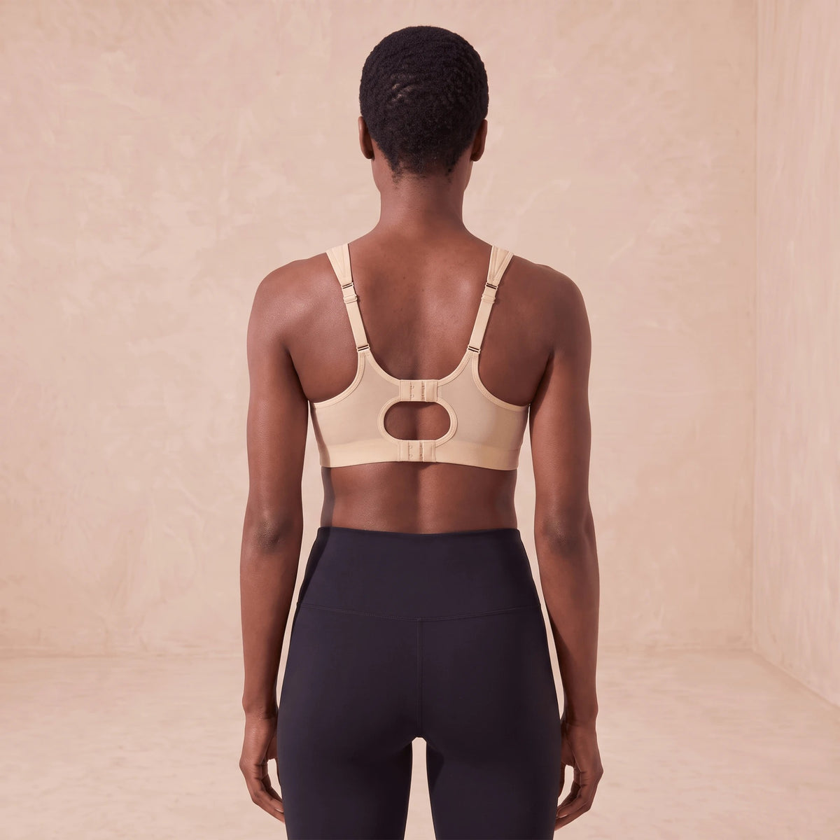 Dos de la brassière beige avec ouverture ovale, bretelles réglables et double fermeture à agrafes