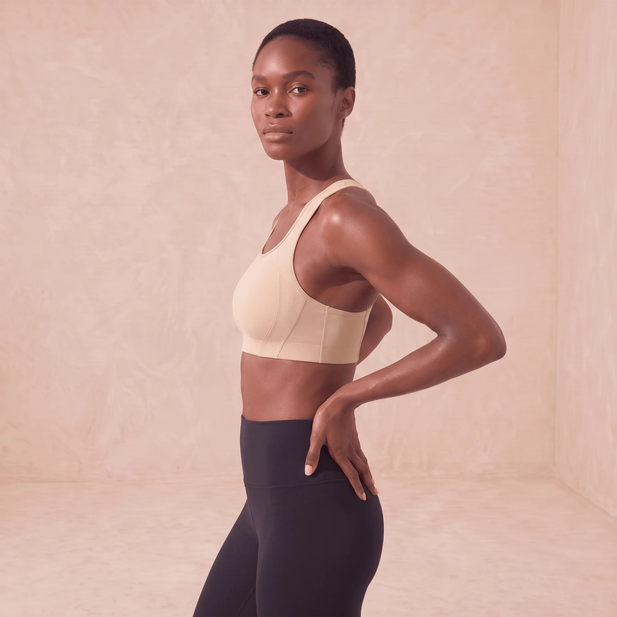 Brassière de sport beige vue de profil, panneaux latéraux en mailles aérées