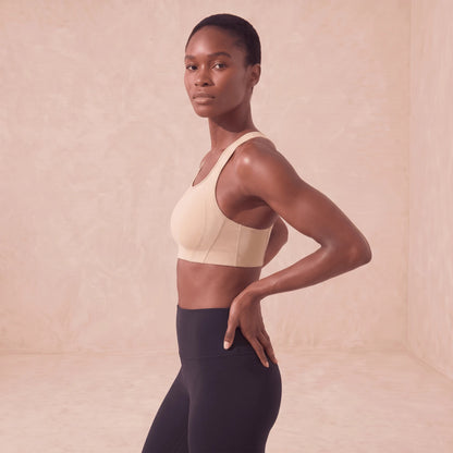 Brassière de sport beige vue de profil, panneaux latéraux en mailles aérées