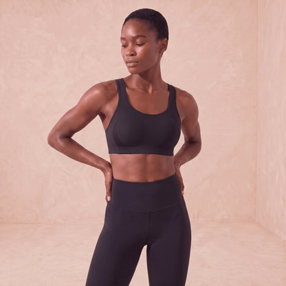 Brassière de sport noire à maintien élevé, portée de face, couverture complète