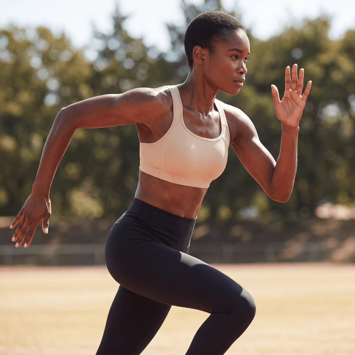 Femme qui court en extérieur avec la brassière de sport rose clair