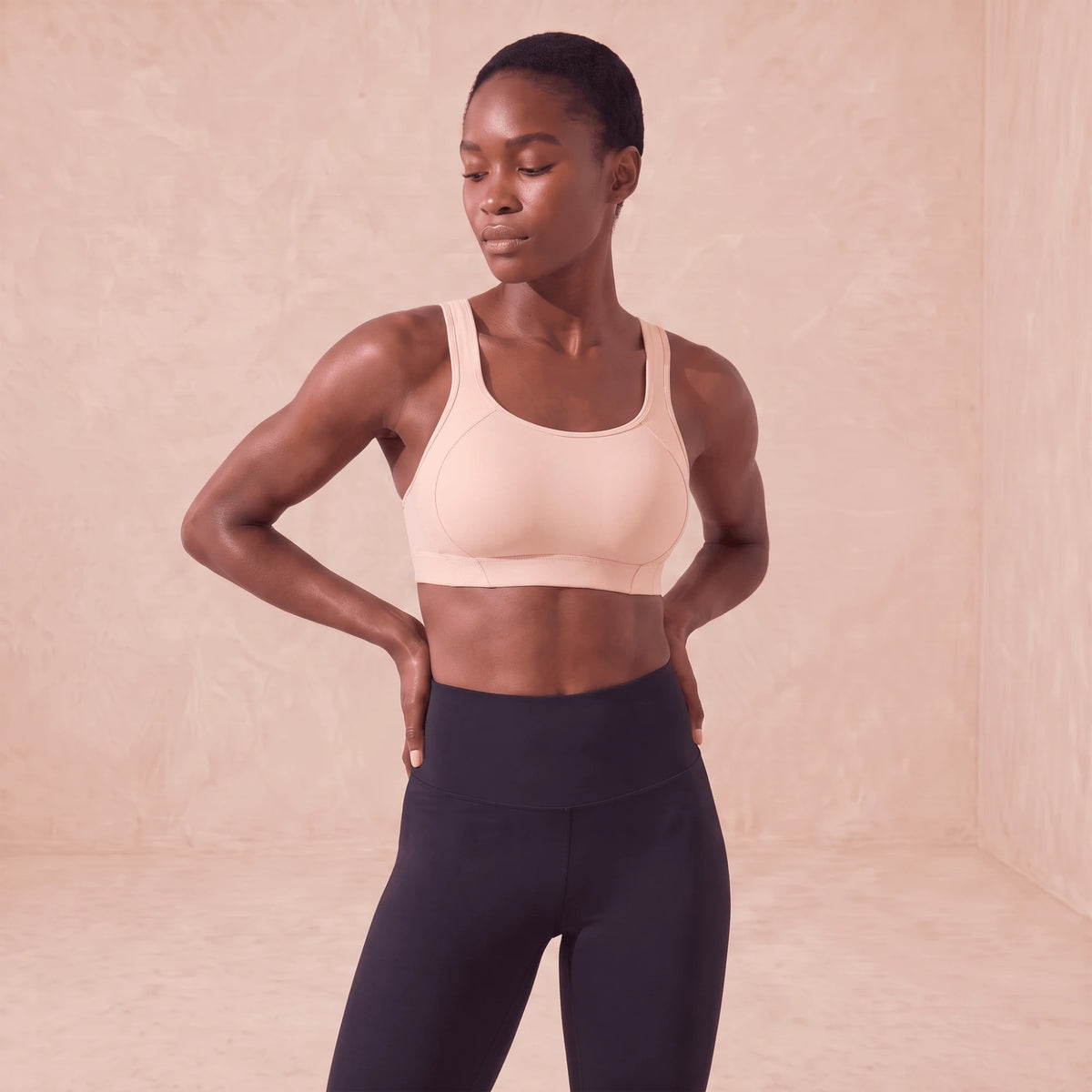 Brassière de sport rose clair à bonnets rembourrés, portée avec un legging noir
