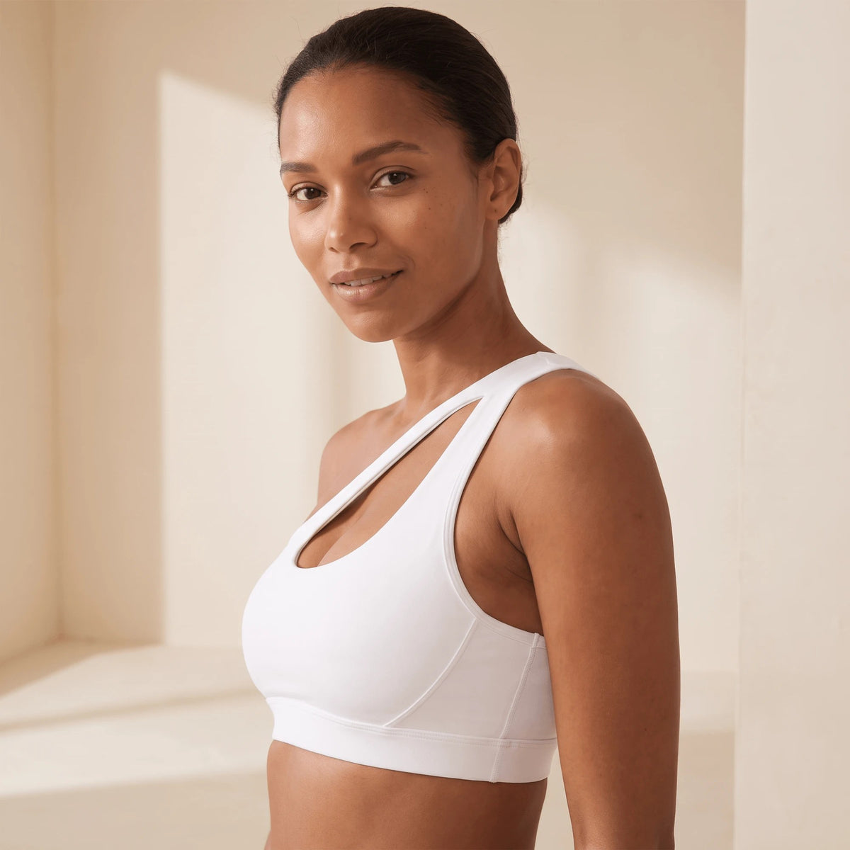 Soutien gorge de sport blanc à une épaule vu de profil, bande large et coutures de maintien
