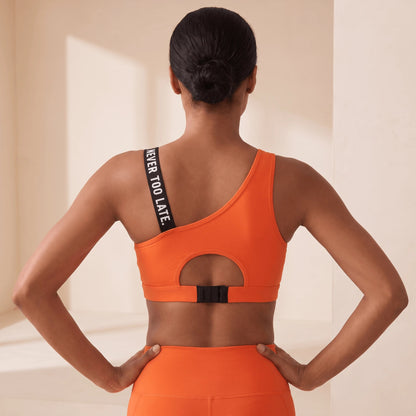 Brassière de sport orange dos nu avec découpe ronde et fermeture à agrafes dans le dos, bretelle à message