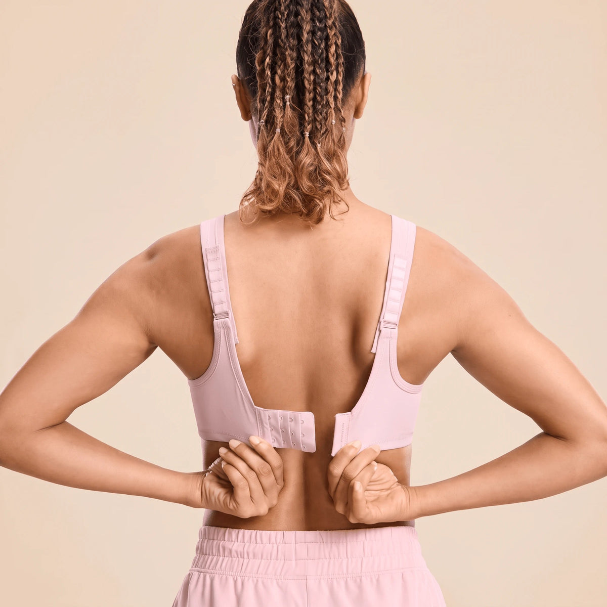 Dos d'une brassière fitness rose avec fermeture à crochets à 4 colonnes et 3 rangées