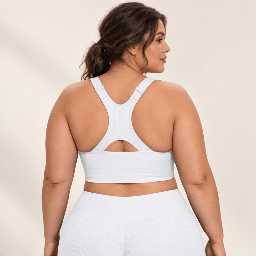 Brassière running maintien fort blanche en grande taille, dos nageur à découpe, studio fond ivoire.