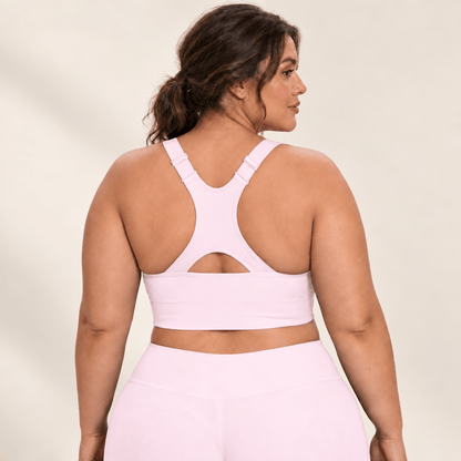 Brassière running maintien fort rose en grande taille, dos nageur à découpe, studio fond ivoire.