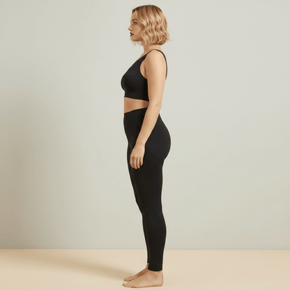 Vue de profil d'une brassière sport grande taille sans couture noire : galbe naturel de la poitrine et bande basse à plat