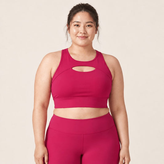 Brassière sport impact élevé push-up rouge framboise portée de face, plan buste, découpe en goutte à l'encolure et bande large