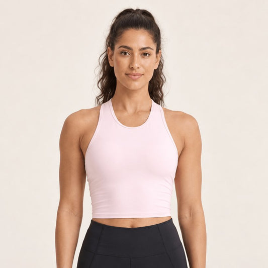Brassière yoga rose poudré, débardeur court à coussinets intégrés et encolure haute dégagée, portée de face en plan buste