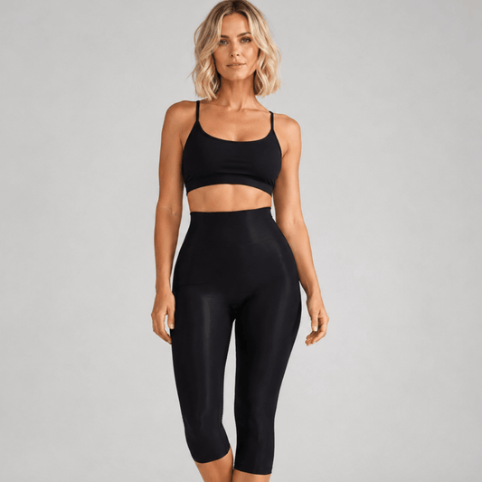 Collant anti cellulite noir vue de face, taille haute, maintien ventre plat, studio gris clair.