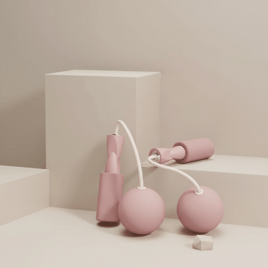 Corde à Sauter Sans Corde blush rose mat, deux poignees ergonomiques avec grips mousse, cordons silicone blancs courts et deux boules lestees, studio ivoire chaud minimaliste