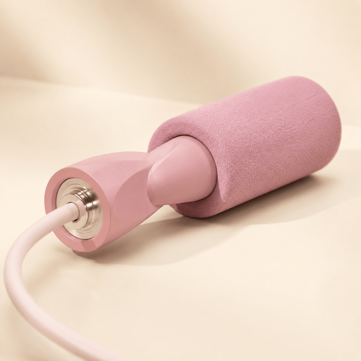 Corde à Sauter Sans Corde, zoom sur les poignees blush mat avec grips mousse, bagues metalliques et debut des cordons silicone blancs, studio ivoire chaud
