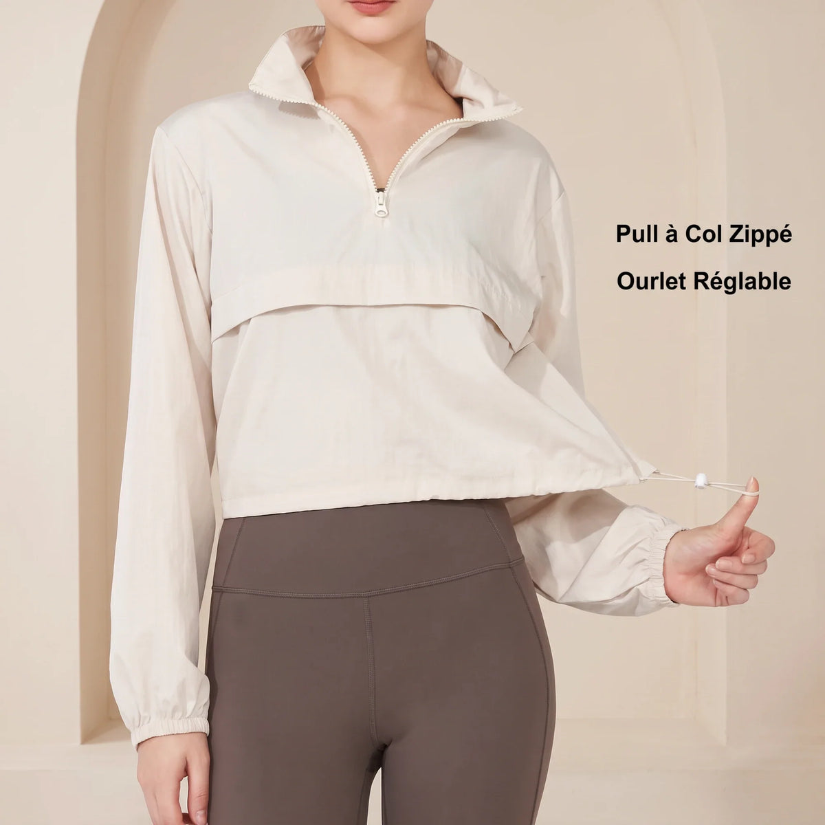 Détail du coupe-vent femme beige : col zippé au quart, ourlet réglable par cordon et poignets élastiqués