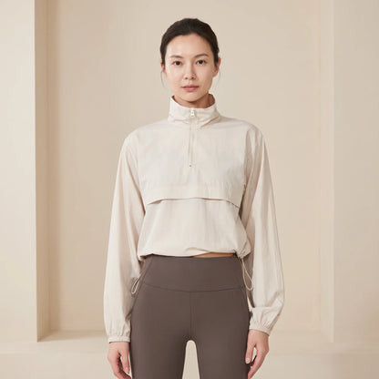 Coupe-vent femme court beige porté de face, col montant zippé et ourlet à cordon réglable