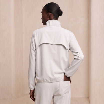 Coupe-vent femme running pliable ivoire vu de dos, empiècement et ourlet resserré