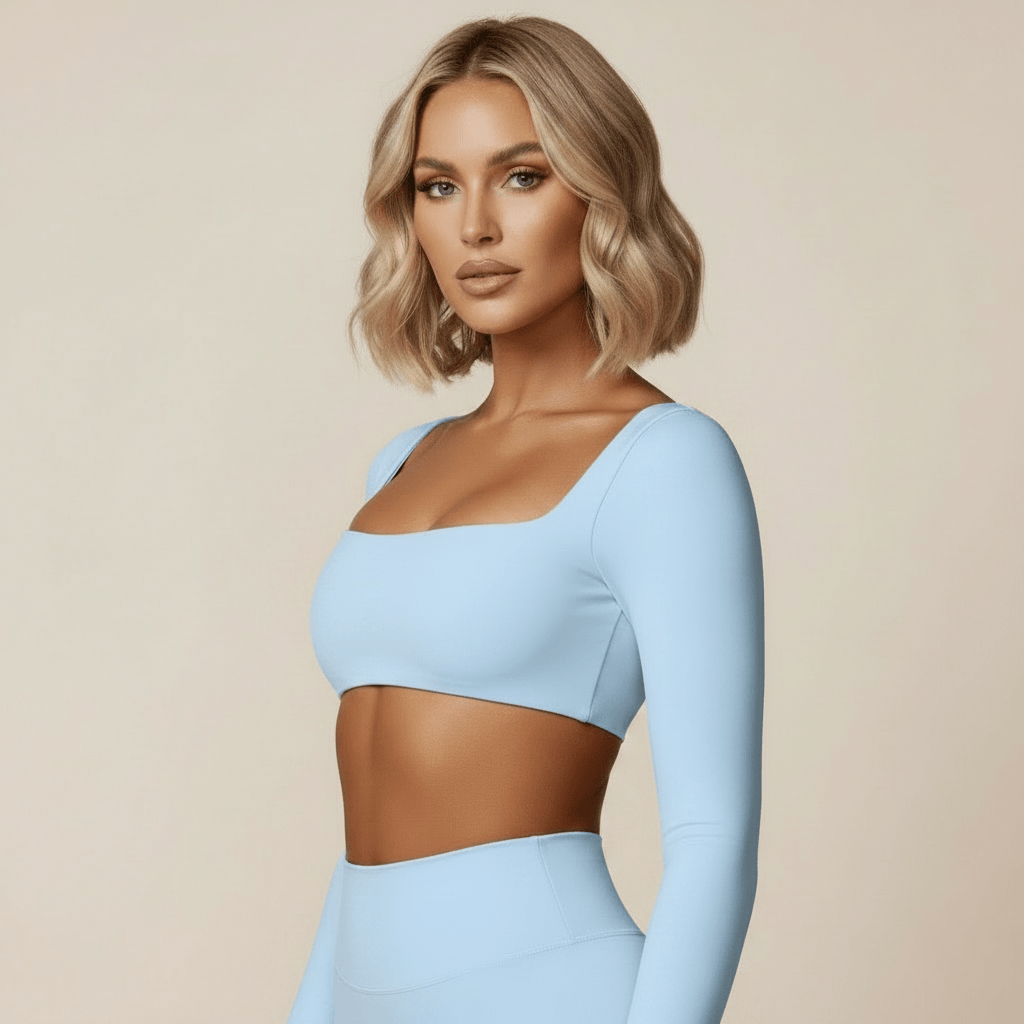 Crop Top Manche Longue Femme, ensemble sport bleu ciel col carre, pose 3/4 chic, mannequin blonde carre wavy, photo studio ivoire doux