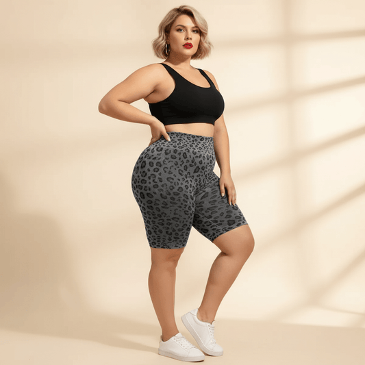 Cycliste sport grande taille imprimé léopard gris et noir seamless taille haute gainant, vue de face trois-quarts main sur la hanche, fond studio crème