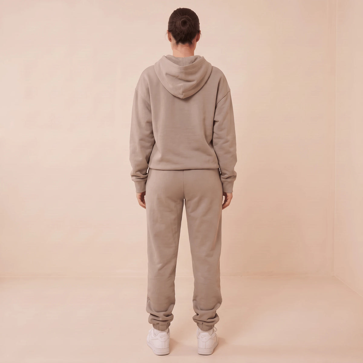 Ensemble de jogging femme taupe vu de dos : capuche, sweat à manches longues et pantalon de jogging