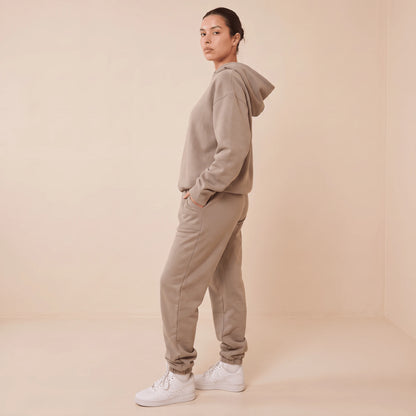 Ensemble de jogging femme taupe vu de profil : capuche, poche du pantalon et bas de jambe élastiqué