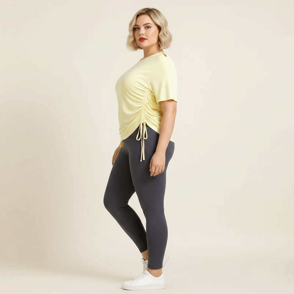 Haut de sport grande taille femme jaune pastel cordons de serrage vue profil froncé latéral fond studio crème