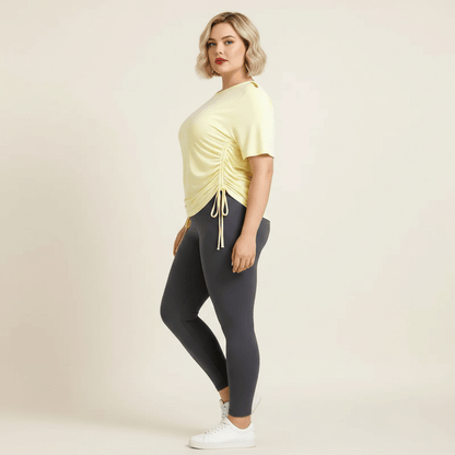 Haut de sport grande taille femme jaune pastel cordons de serrage vue profil froncé latéral fond studio crème