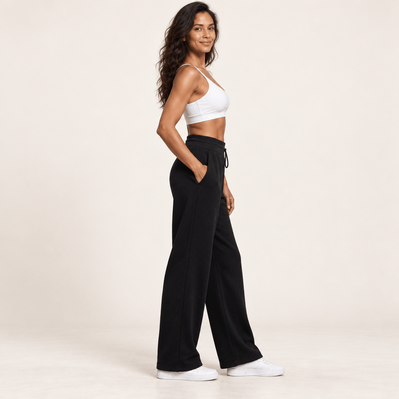 Jogging polaire femme noir vu de profil, jambe large tombant droit depuis la hanche