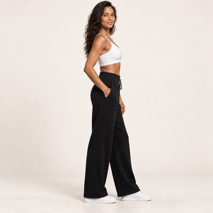Jogging polaire femme noir vu de profil, jambe large tombant droit depuis la hanche