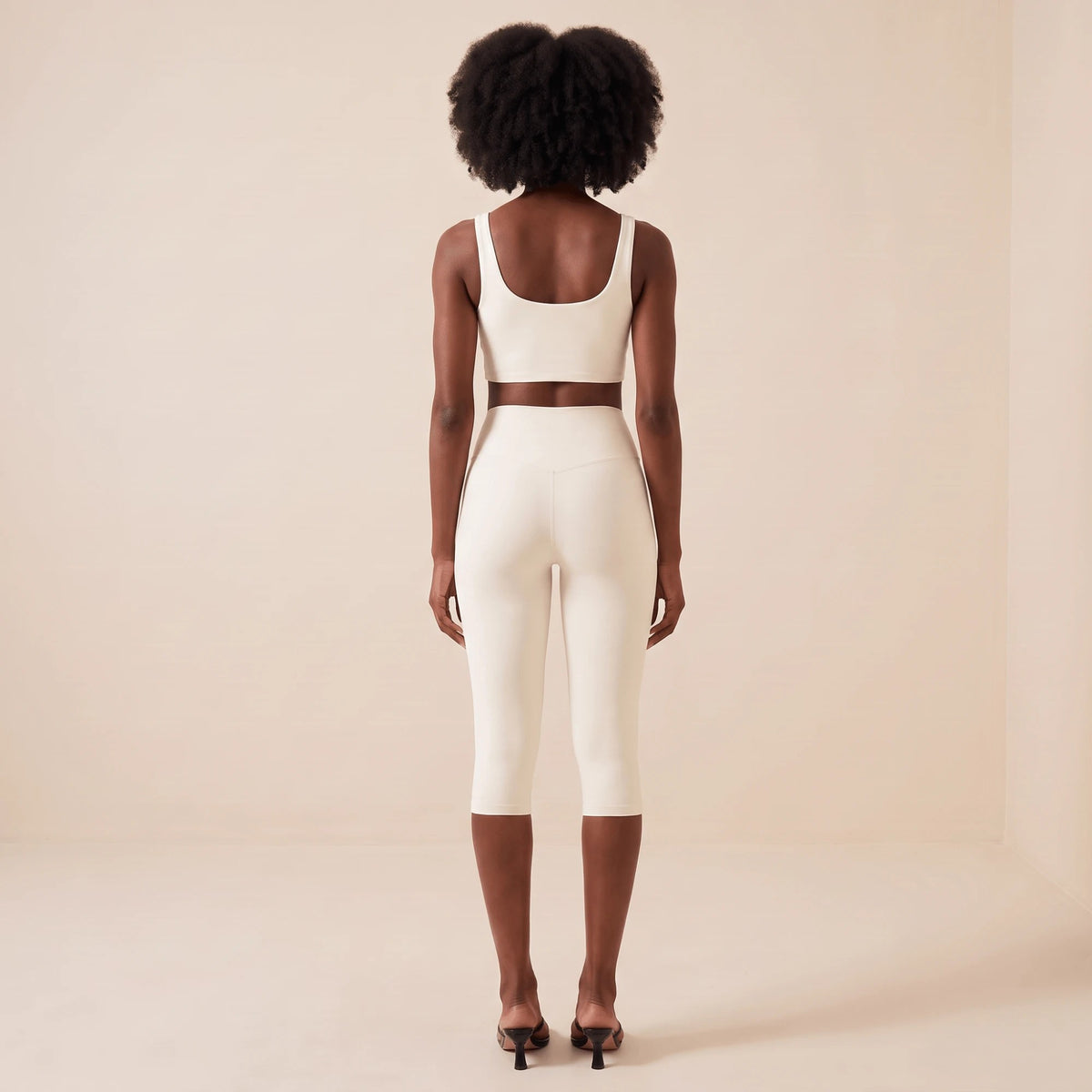 Legging blanc court femme vu de dos en pied : ceinture haute, coupe en V dans le dos et jambe 3/4 élégante