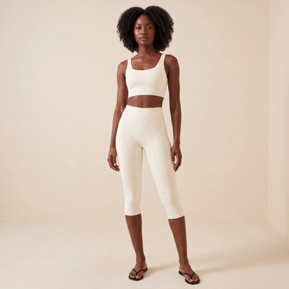 Legging blanc court 3/4 taille haute en blanc ivoire, vue de face en pied : longueur capri sous le genou, large ceinture et brassière blanche assortie