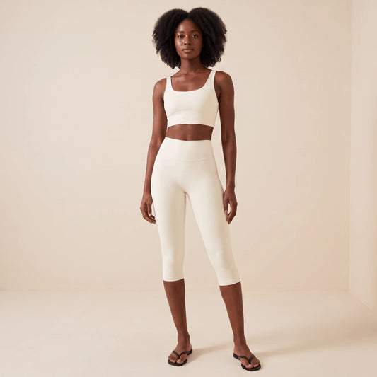 Legging blanc court 3/4 taille haute en blanc ivoire, vue de face en pied : longueur capri sous le genou, large ceinture et brassière blanche assortie