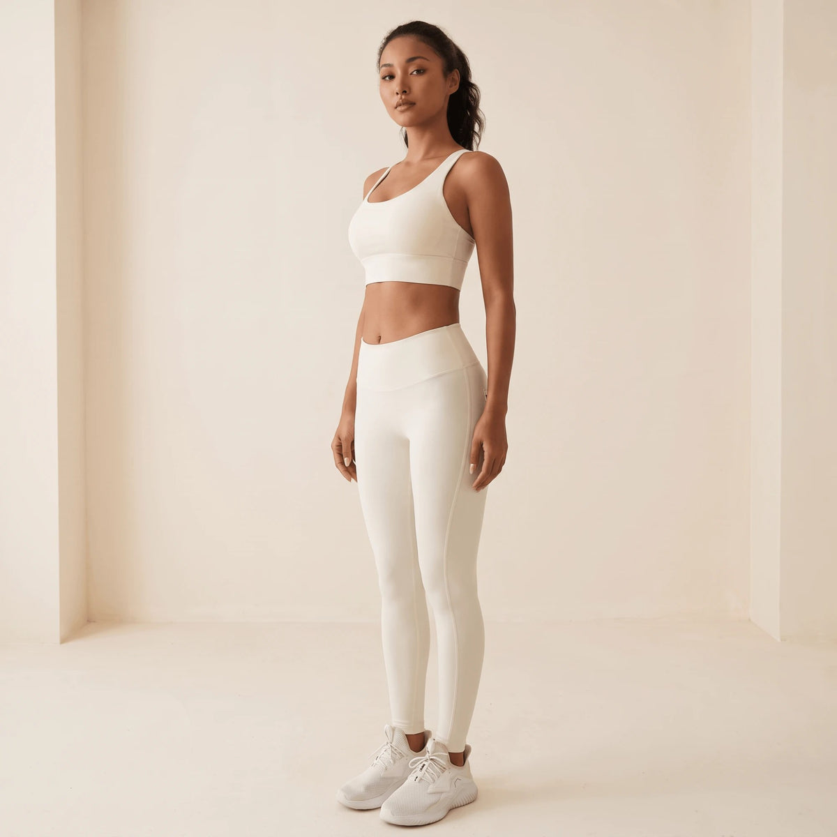 Legging blanc femme pleine longueur debout de trois quarts, bras le long du corps : ligne ajustée de la taille jusqu'à la cheville