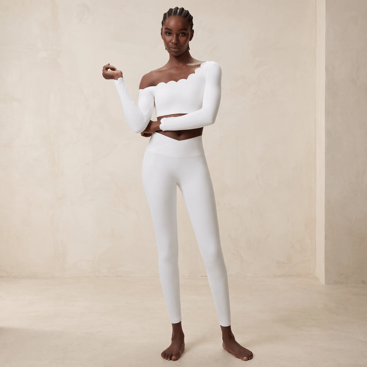 Legging taille croisée en V en blanc : gros plan sur la ceinture croisée qui descend en pointe au centre, mannequin de face