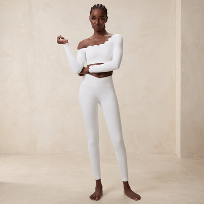 Legging taille croisée en V en blanc : gros plan sur la ceinture croisée qui descend en pointe au centre, mannequin de face