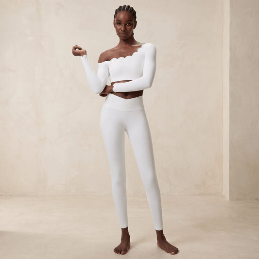 Legging taille croisée en V en blanc : gros plan sur la ceinture croisée qui descend en pointe au centre, mannequin de face